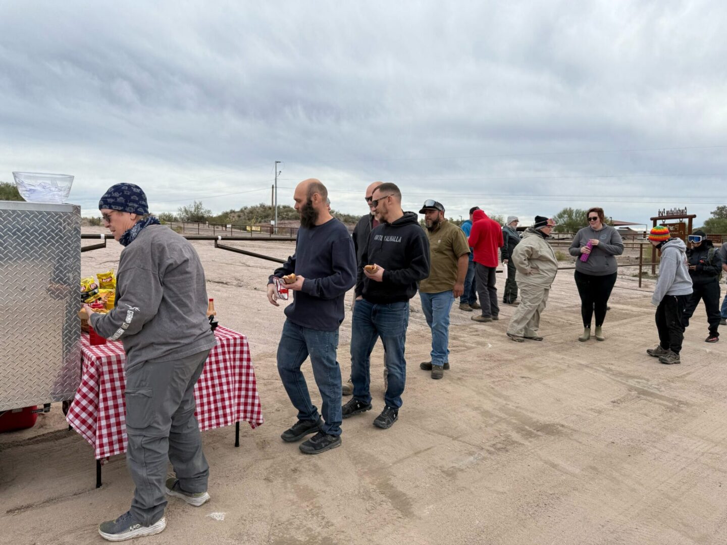 People queued outdoors at a food table