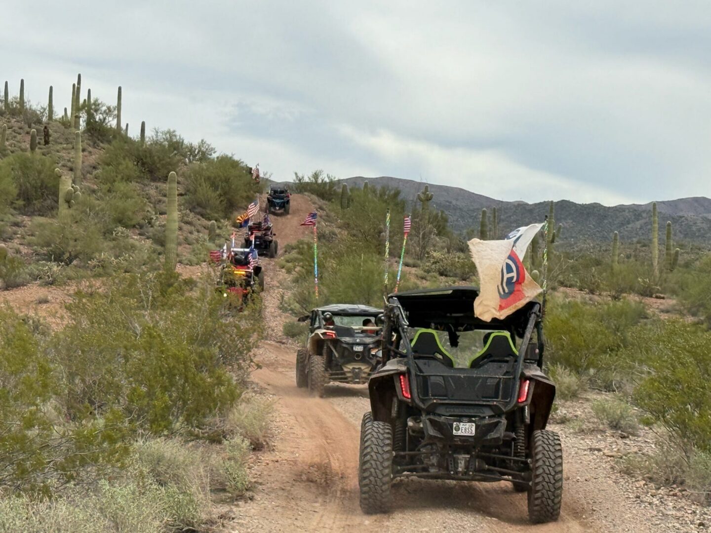 UTVs with flags on desert dirt trail