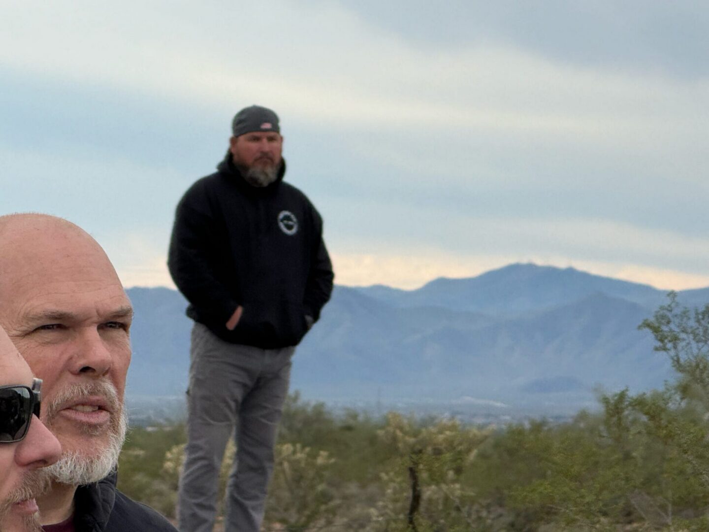 Men standing outdoors with mountain view