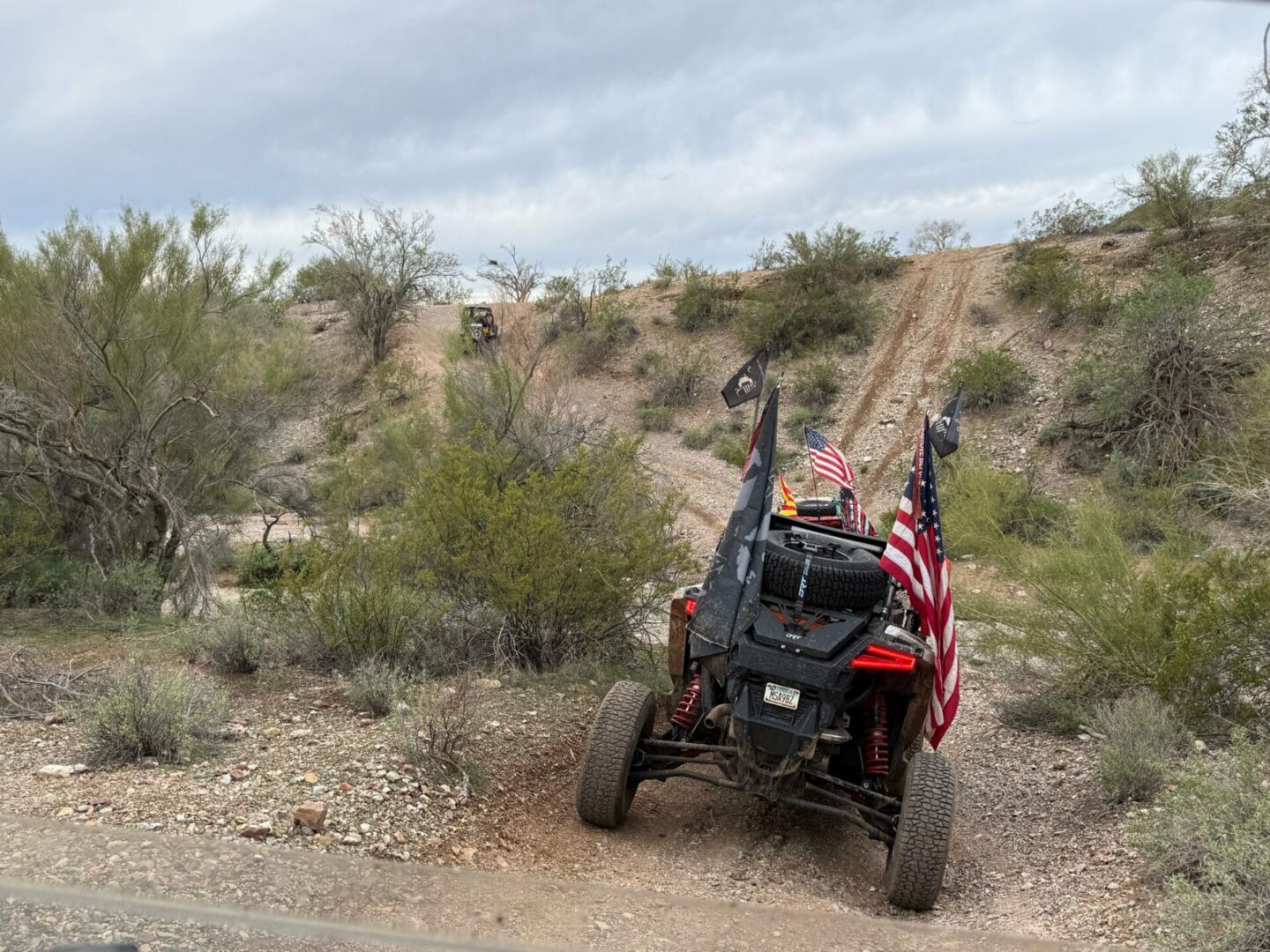 UTV with American flags on desert trail