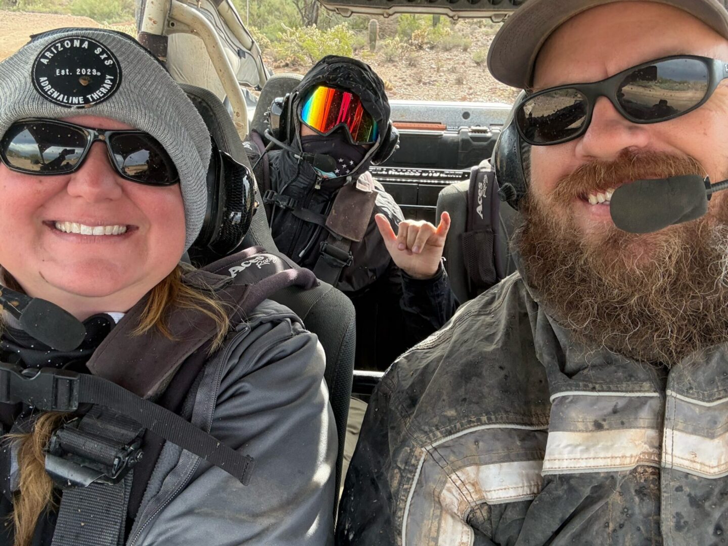 Three smiling riders in off-road vehicle