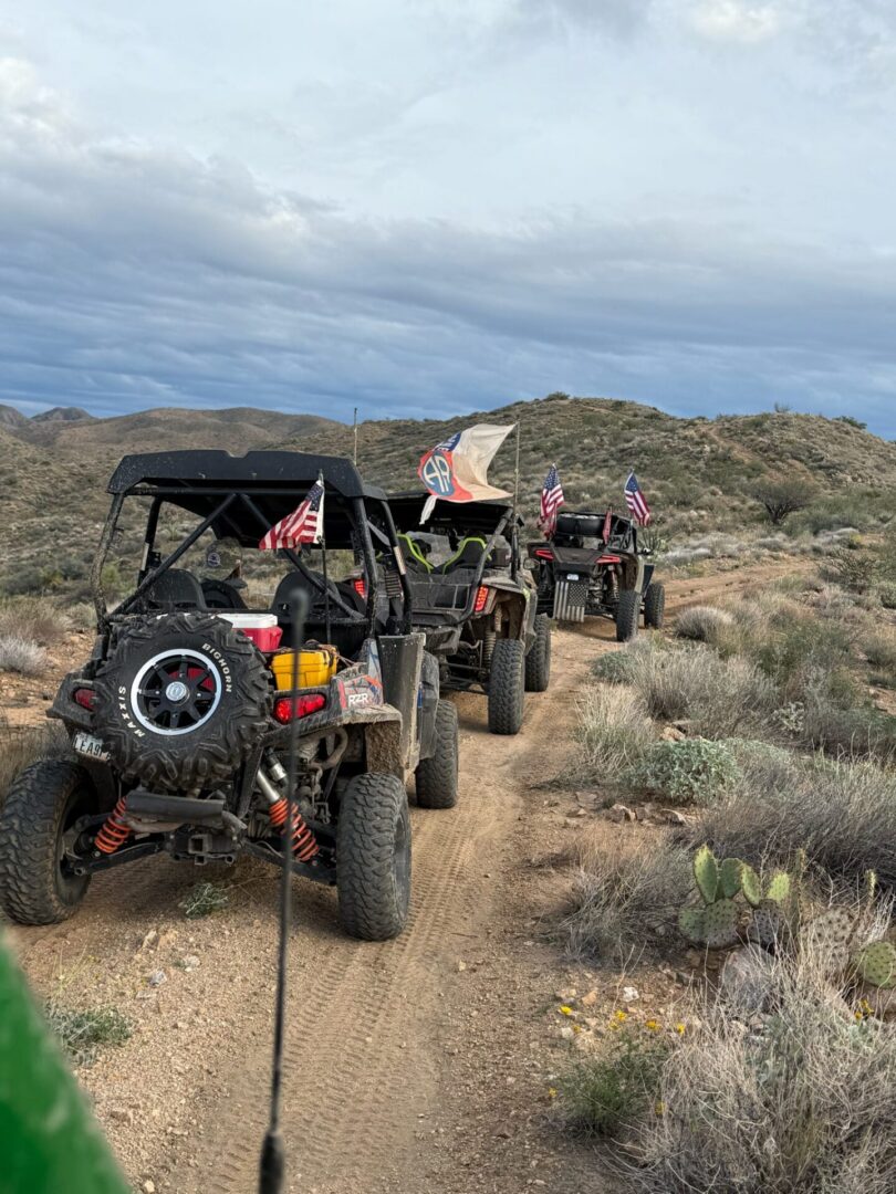 UTVs on desert trail with American flags