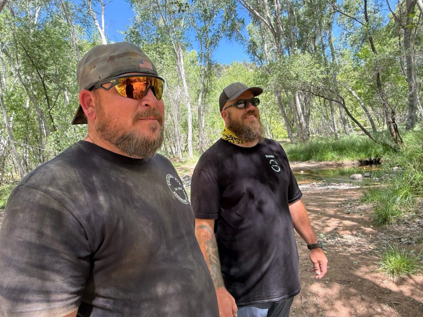 Two bearded men standing on forest trail