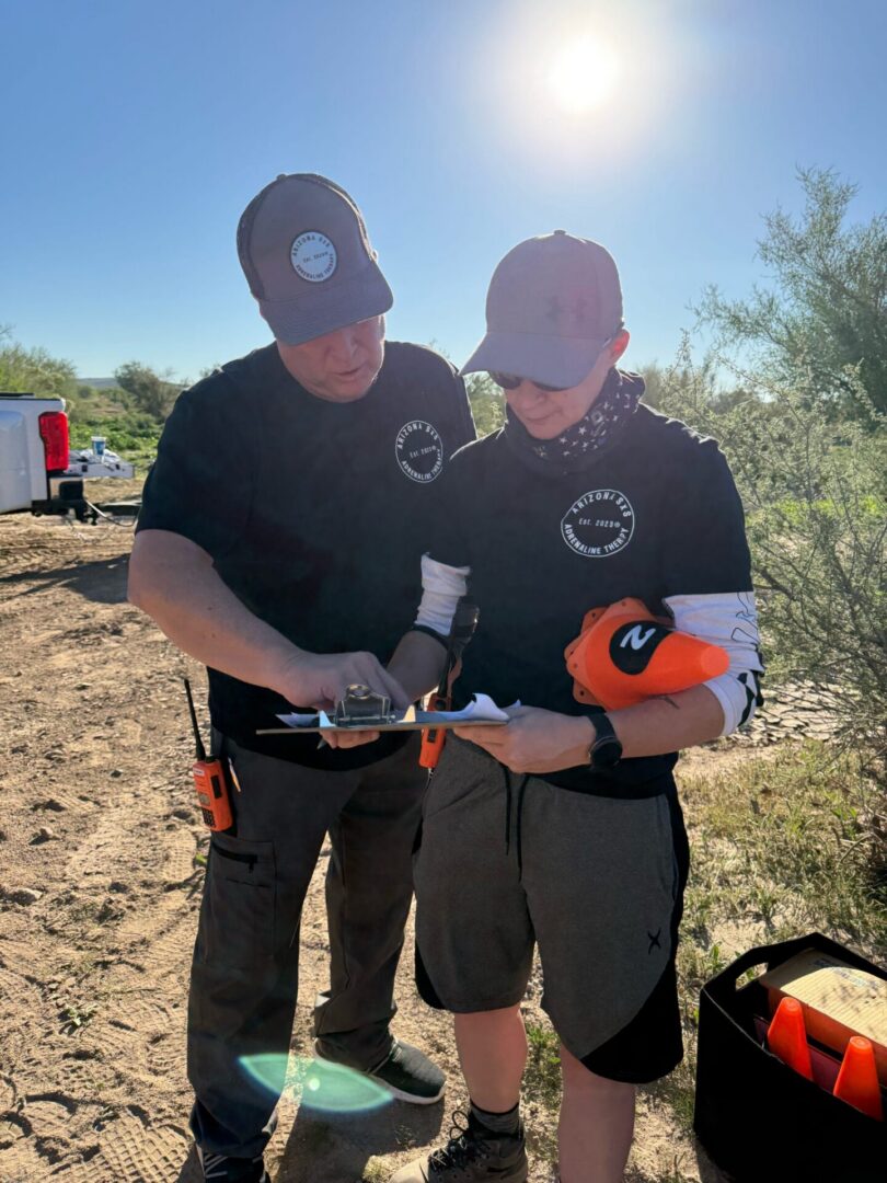 Two people reviewing clipboard in desert