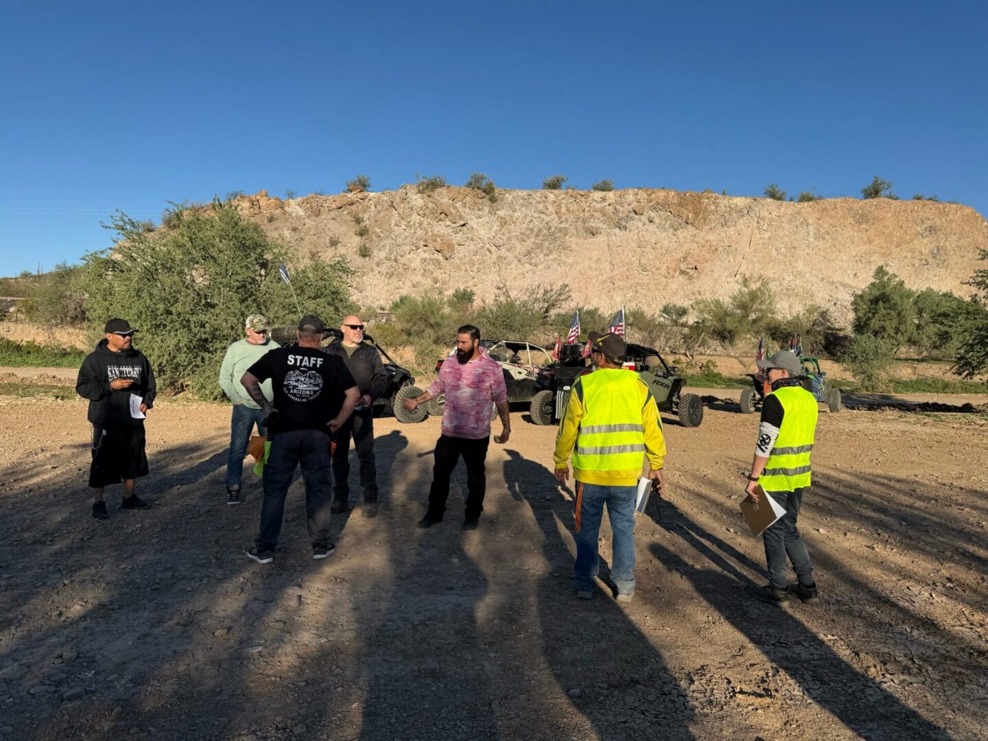 Group of people standing by off-road vehicles