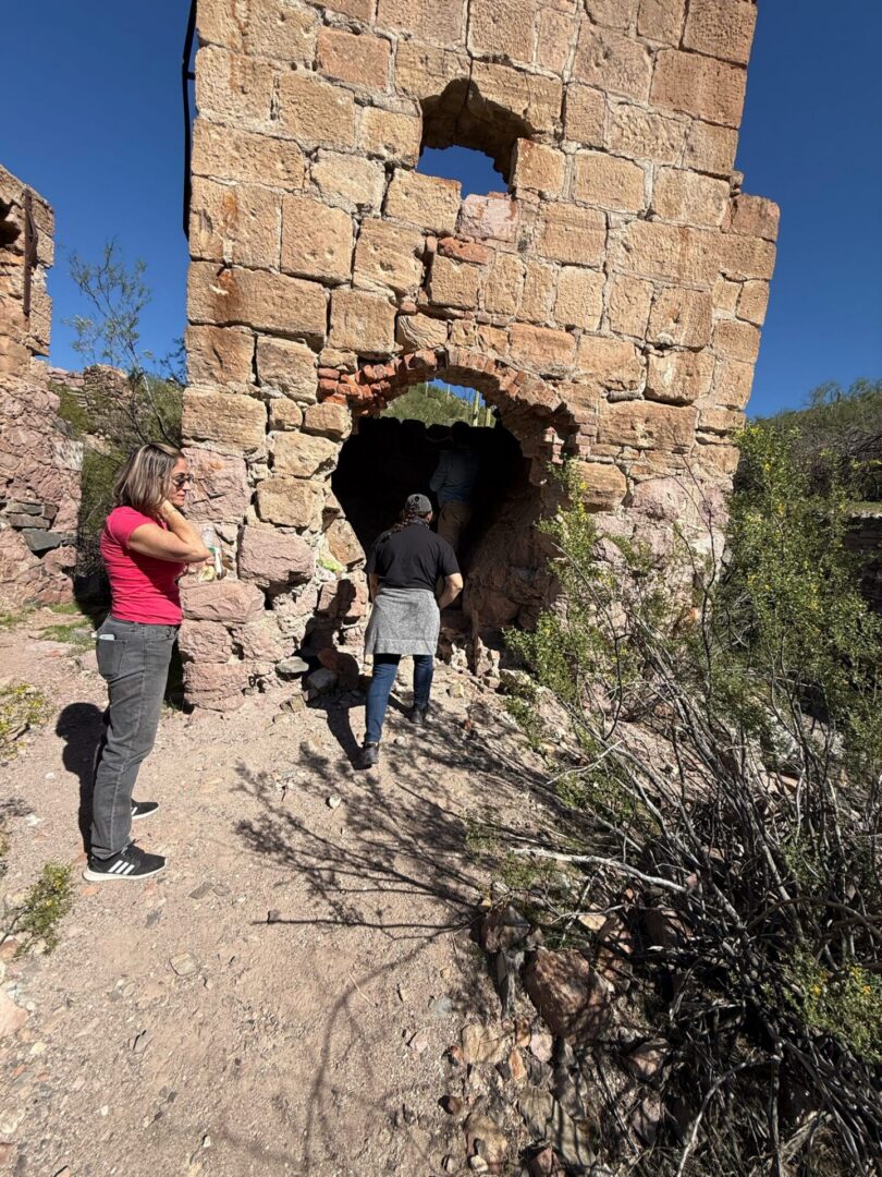 Visitors entering crumbling stone tower ruins