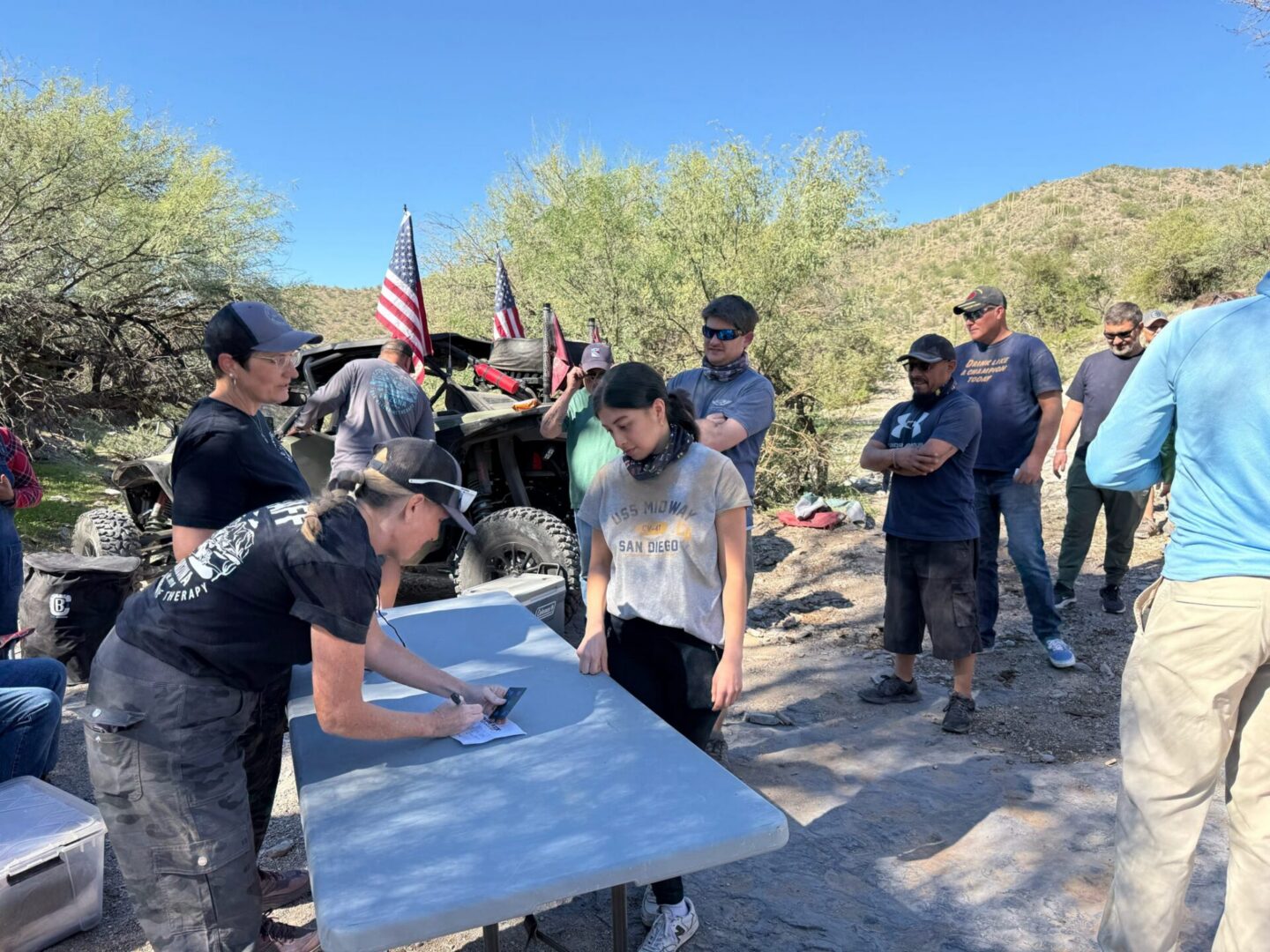 People signing forms at off-road desert meetup