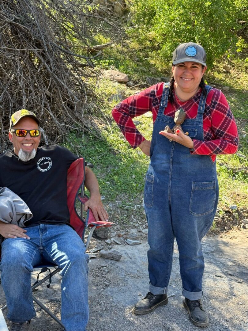Two people outdoors, woman holding small bird