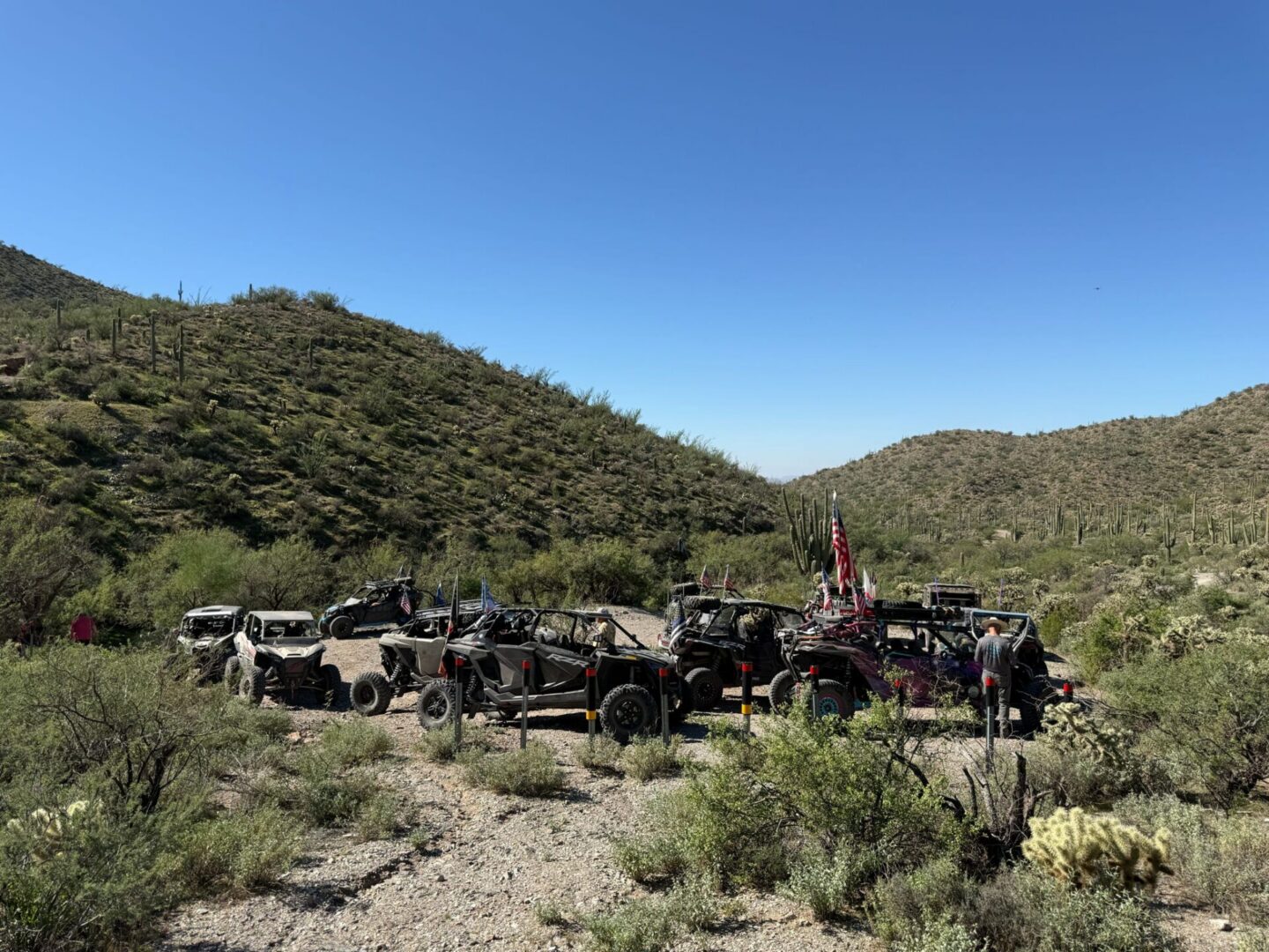 UTVs parked in desert valley with cacti