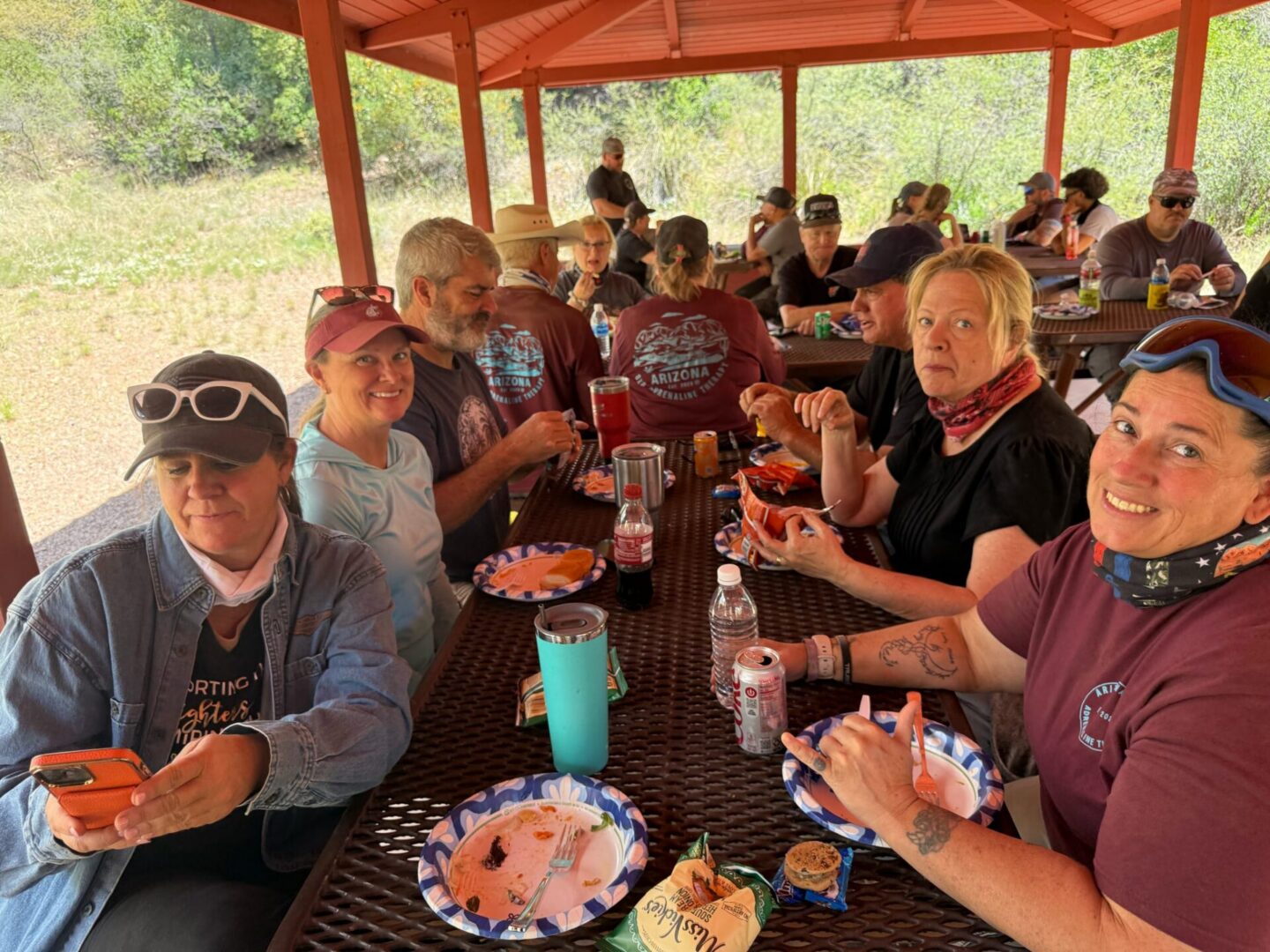 Large group picnic under red park pavilion