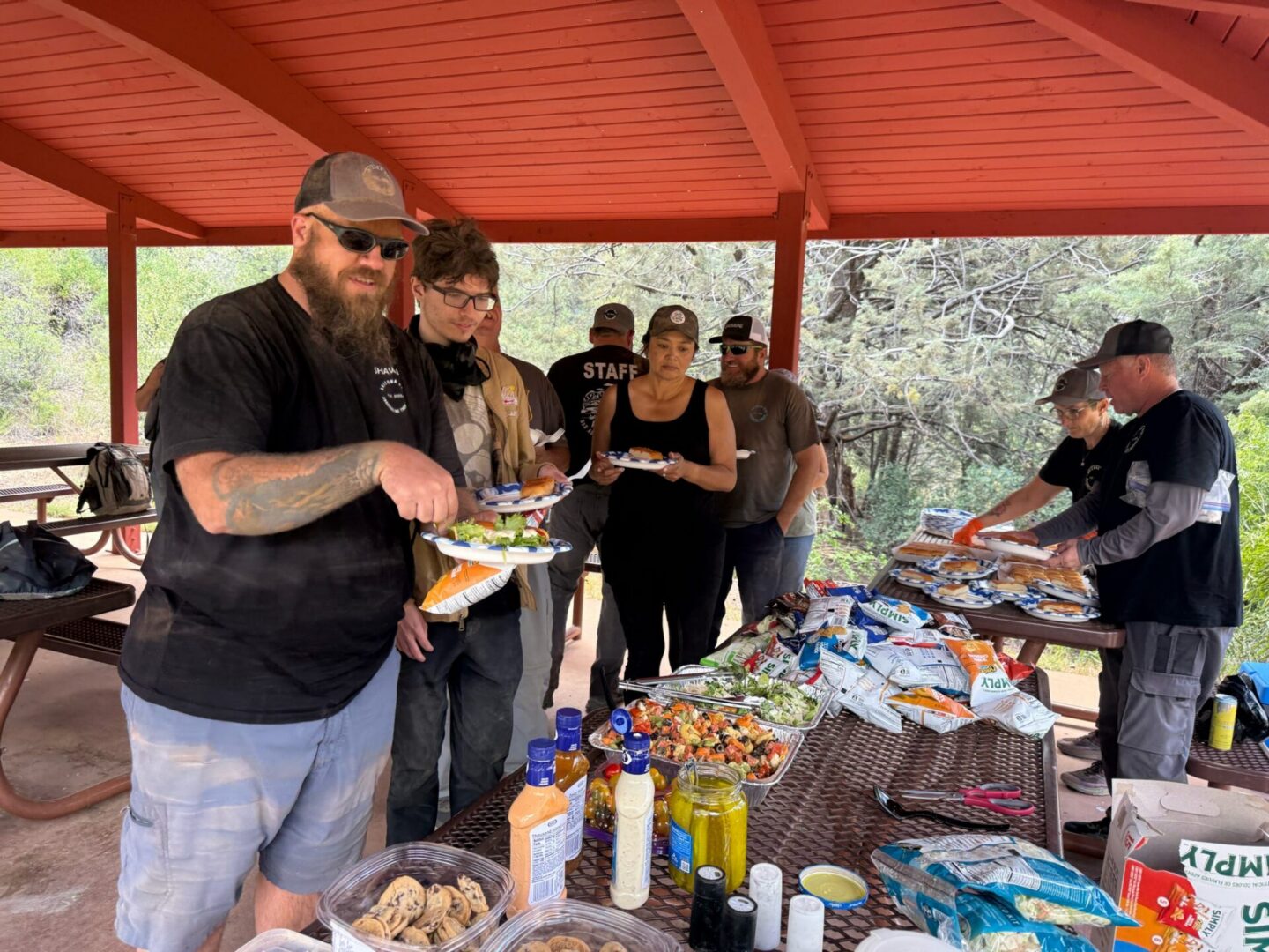 People serving themselves at outdoor picnic buffet
