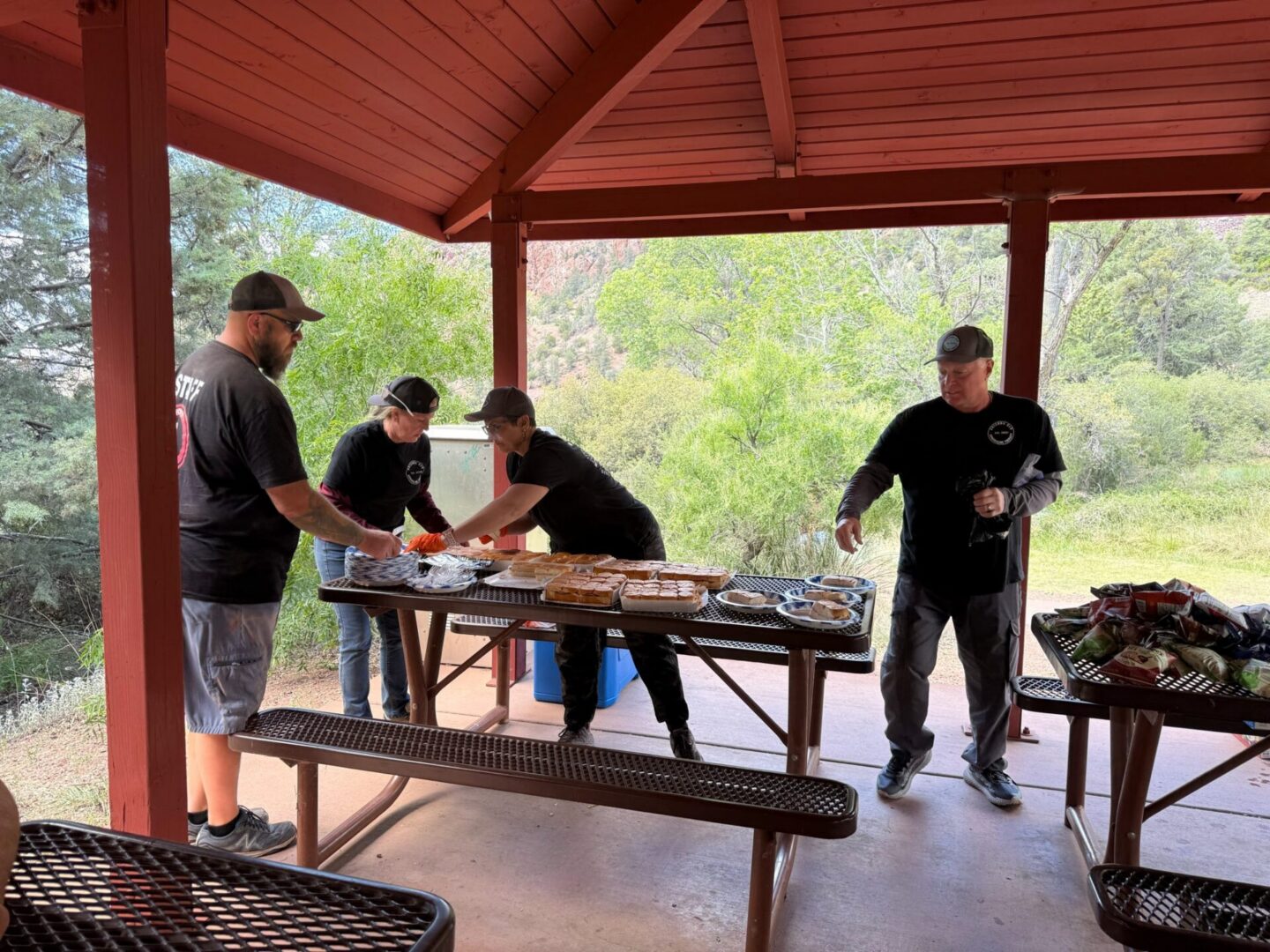 Volunteers serving food at outdoor picnic pavilion