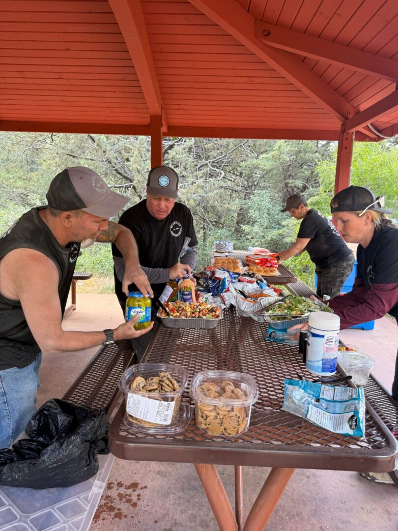 People preparing picnic food under red pavilion