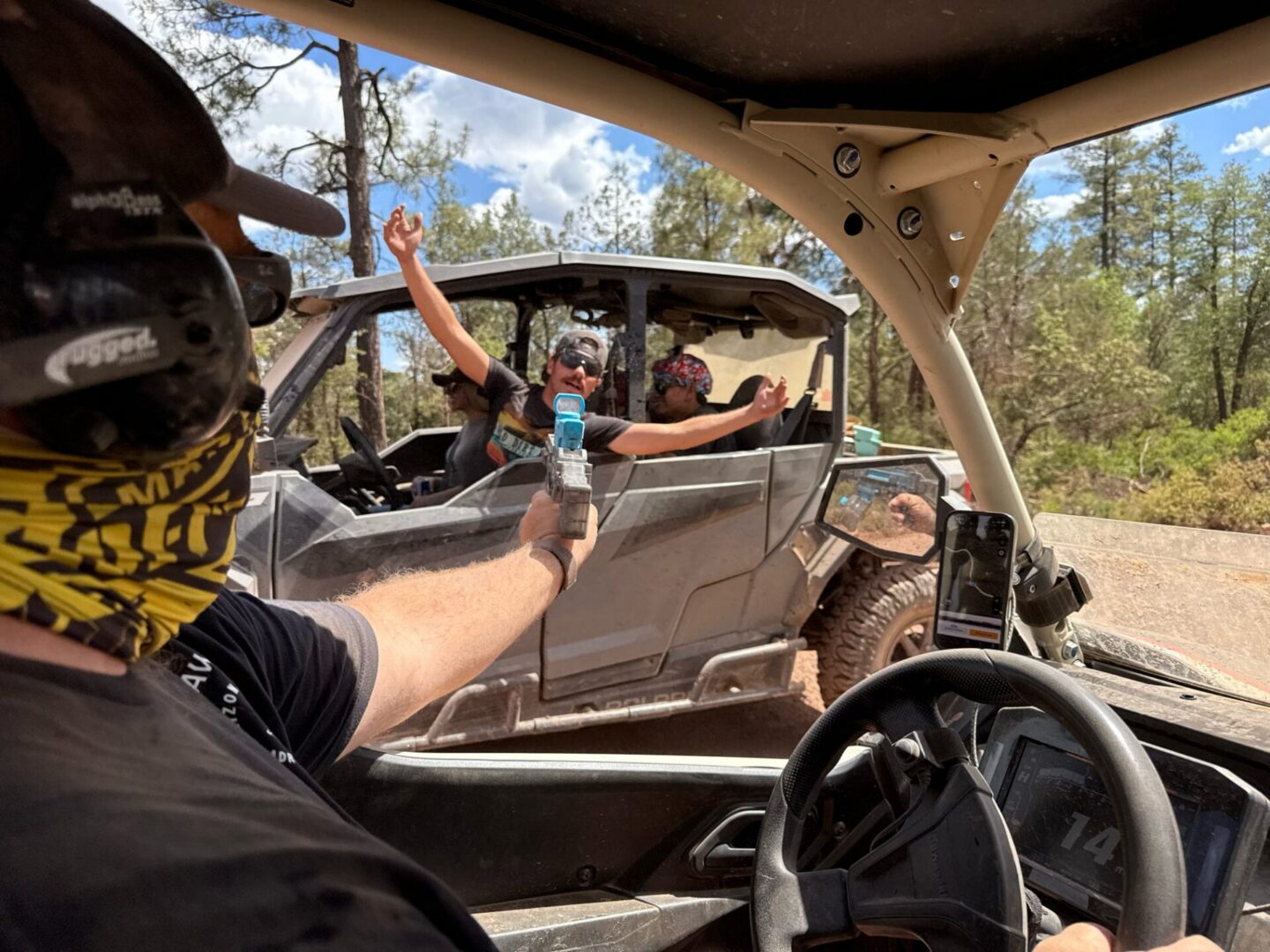 Riders passing water between off-road UTVs