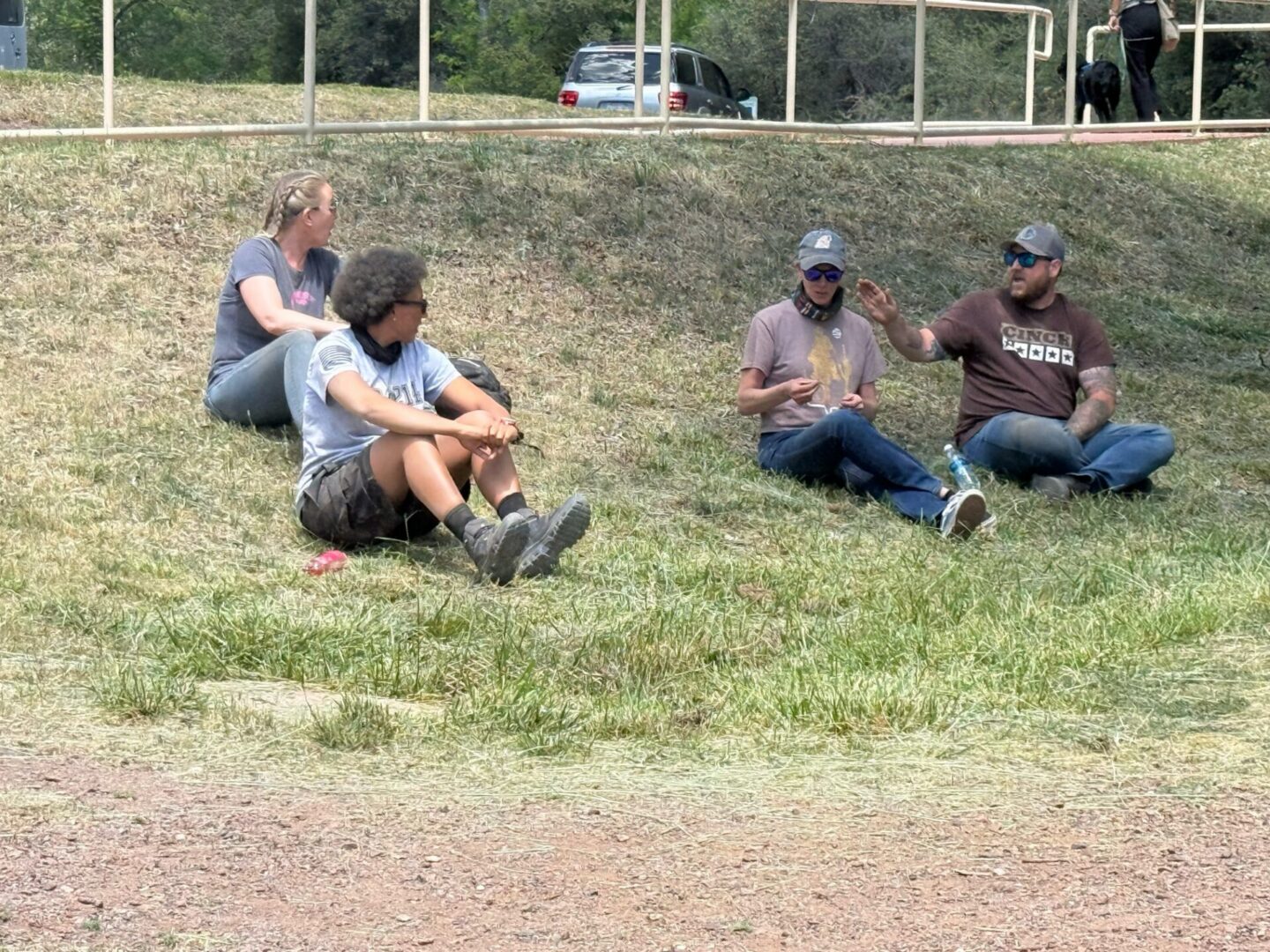 Four people sitting on grassy hillside